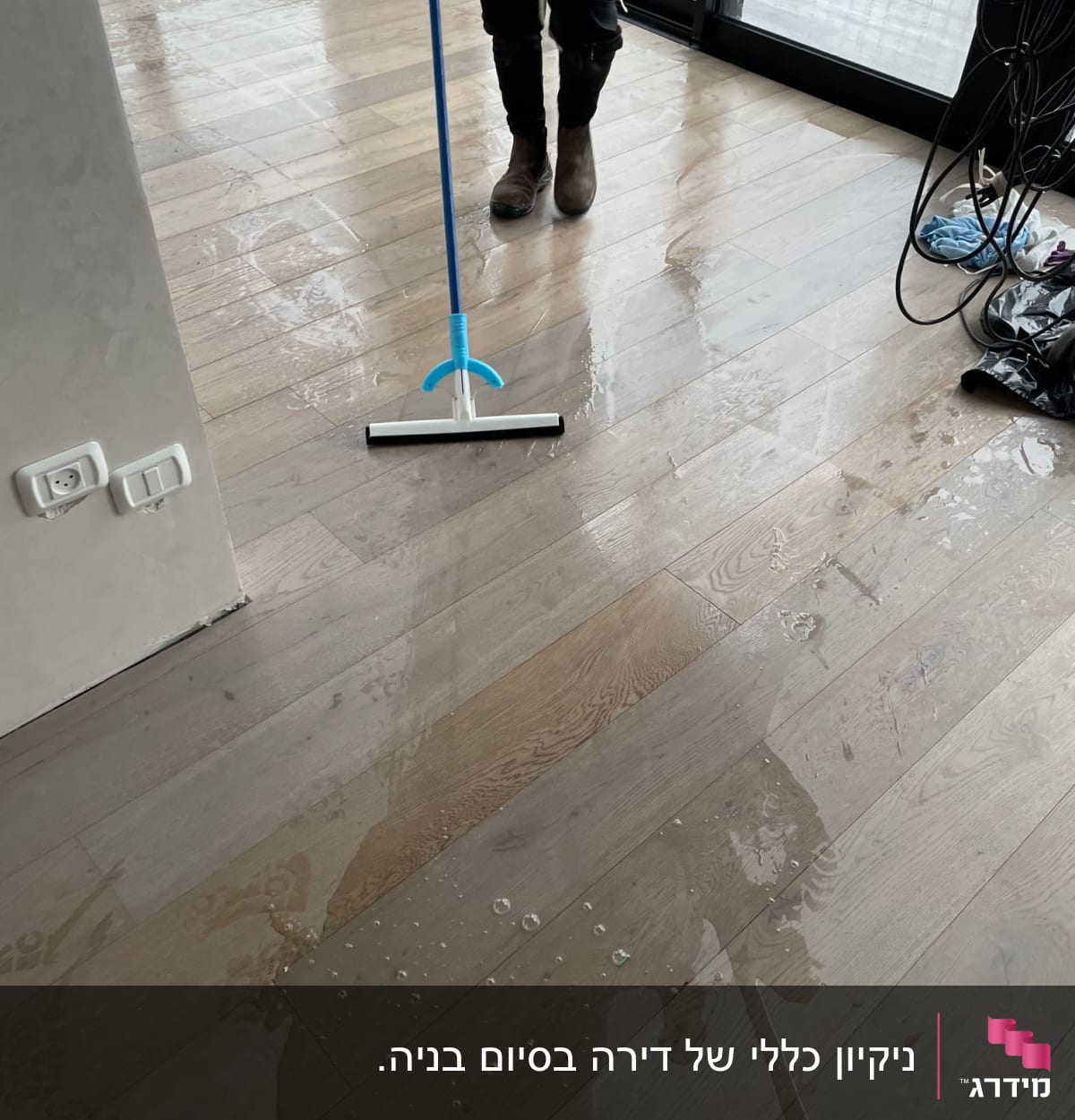 אדם מנקה רצפה רטובה עם מגב